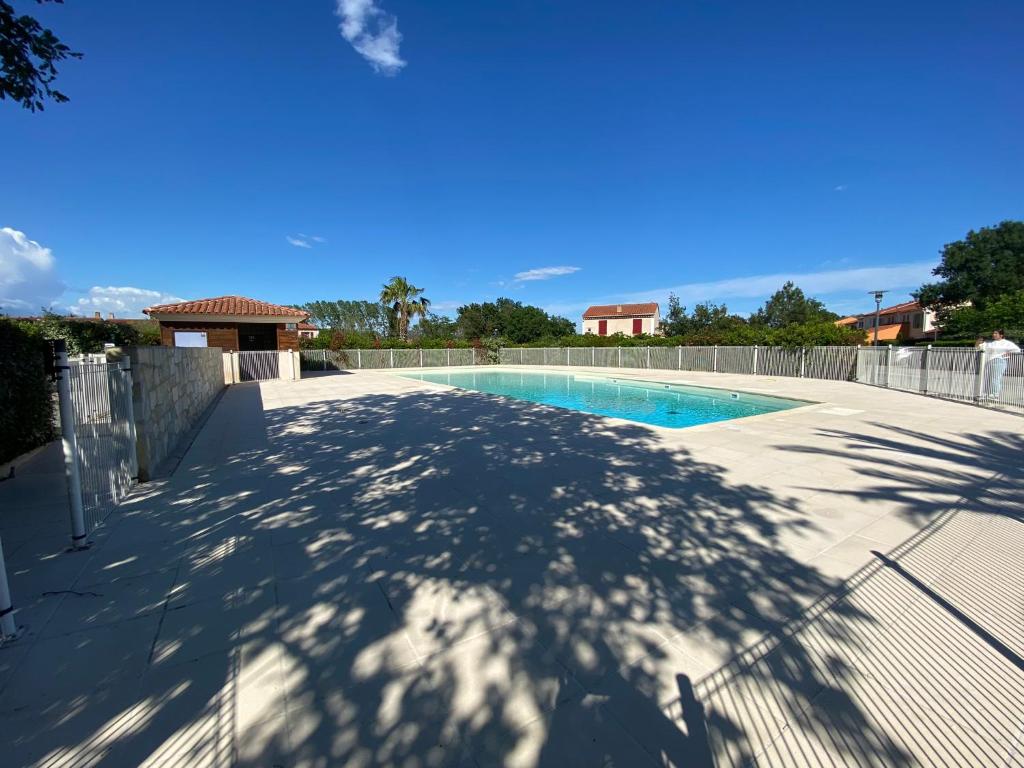 une terrasse avec une piscine et une clôture dans l'établissement Villa 91m2, Piscine, clim, calme, proche plage, à Roquebrune-sur Argens