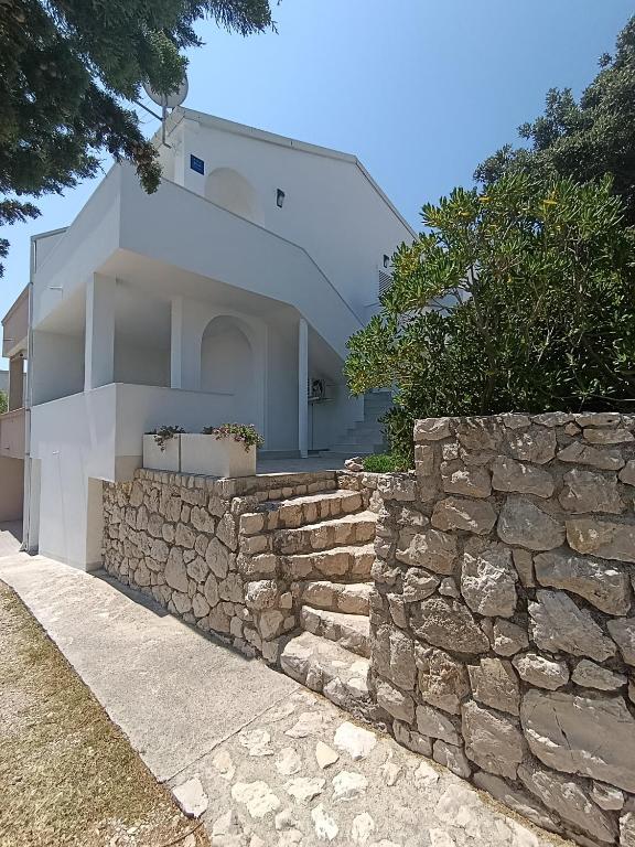 a stone wall in front of a house at Apartments Višnja in Pag