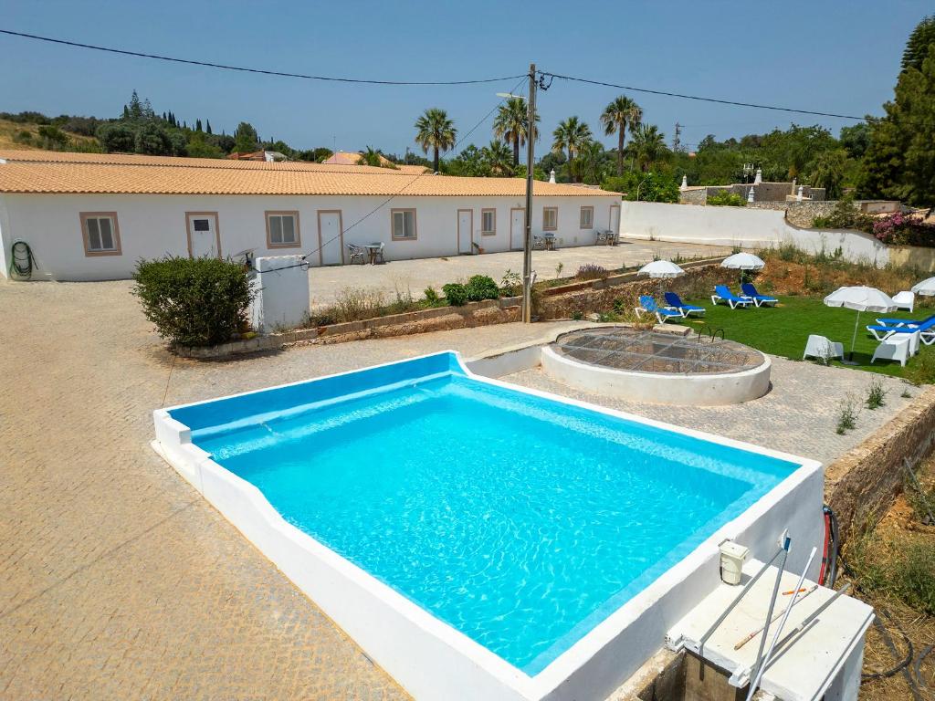 a swimming pool in front of a house at Quinta da Ponte in Odiáxere