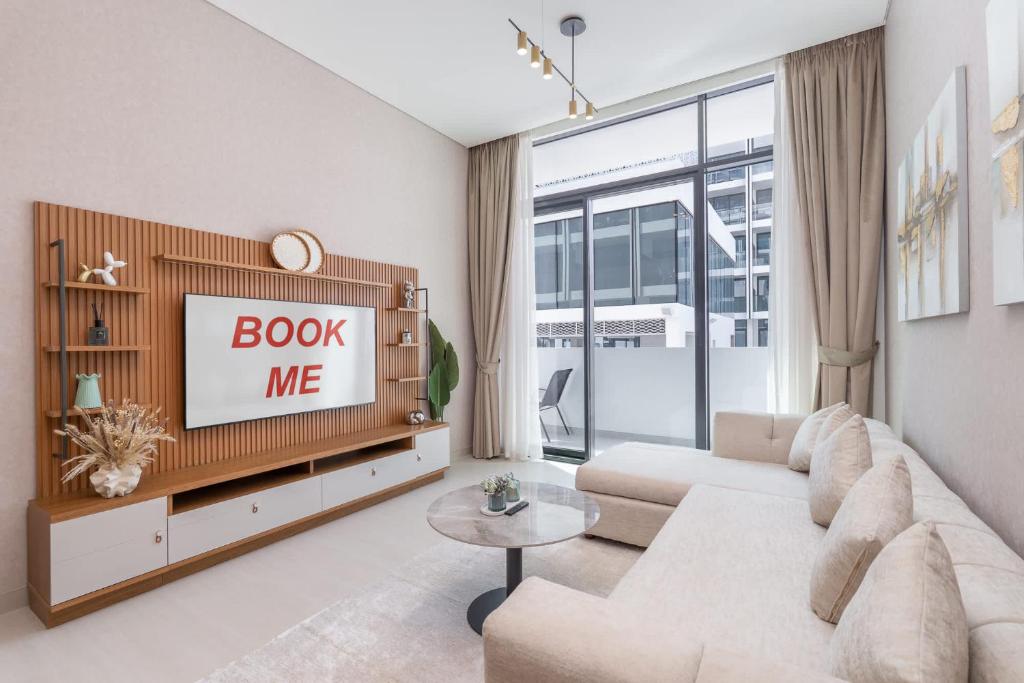 uma sala de estar com um sofá e uma TV em Spacious Apartment for 4 in JVC no Dubai