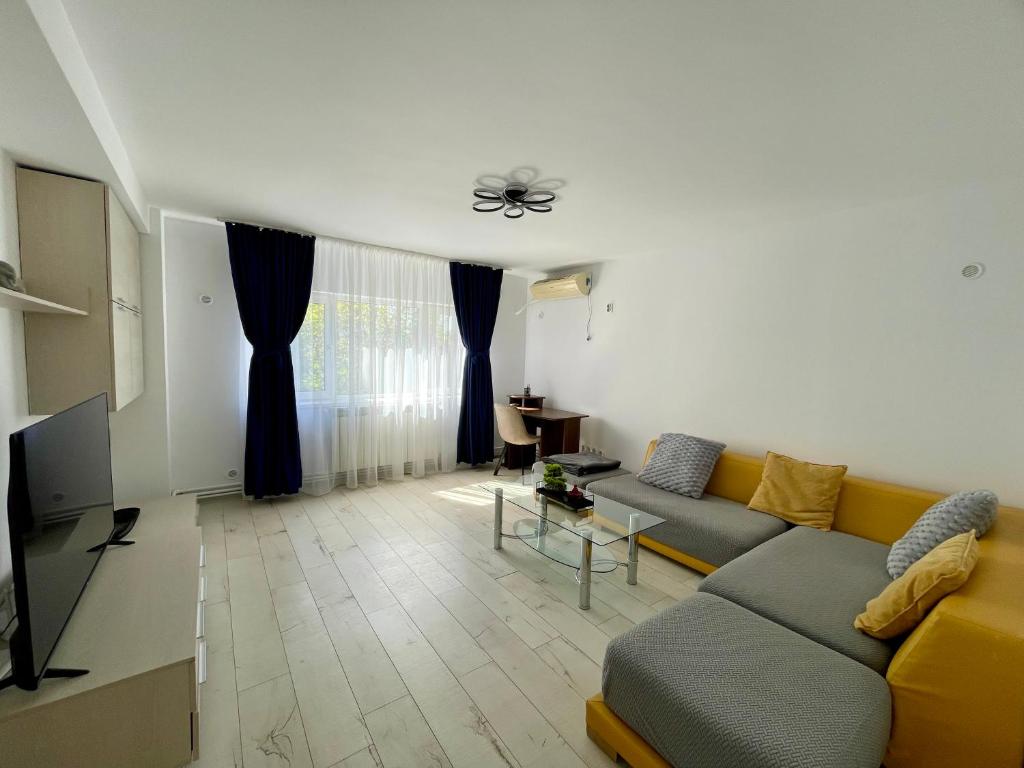 a living room with a couch and a tv at Sea & Stay in Constanţa