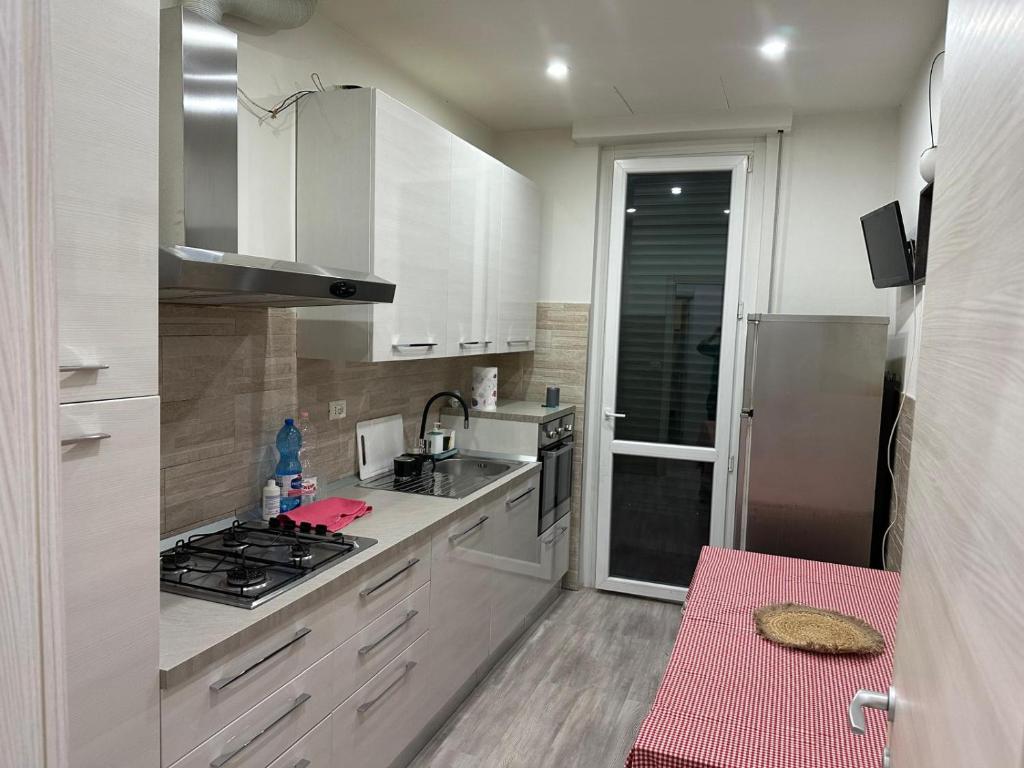 a kitchen with white cabinets and a sink and a stove at Cataleia in Biella