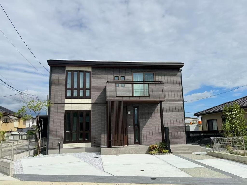 a brown brick house with a large door at Akikawa Miyoshi 7 プレミアム鉄骨 一棟貸切ヴィラ in Kumamoto