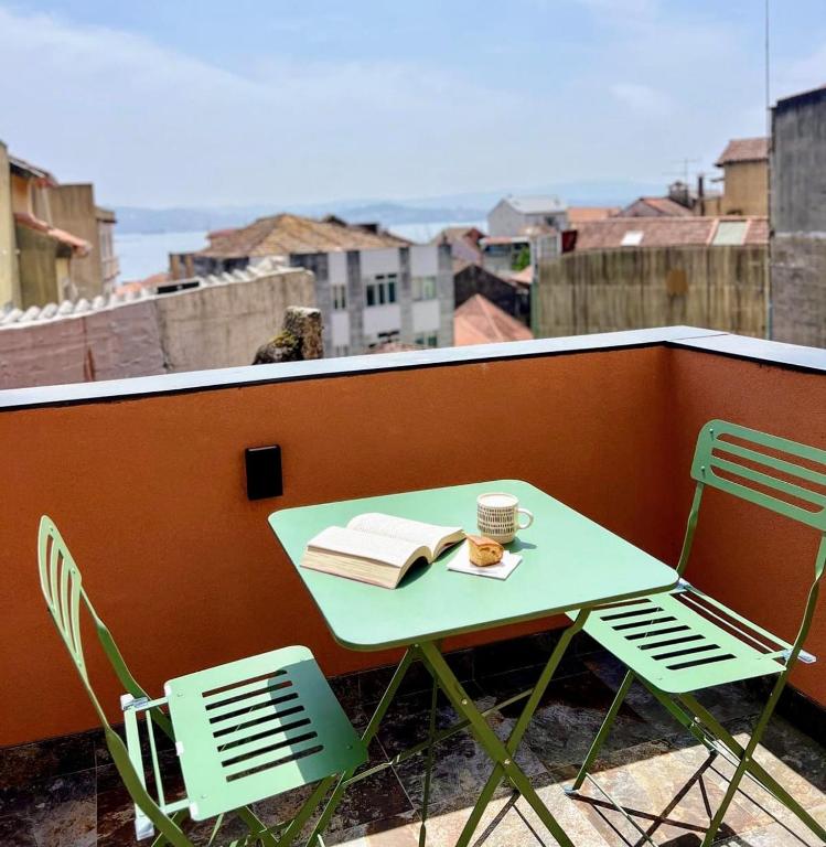 a table and chairs on a balcony with a cup of coffee at A Casiña Laranxa in Cangas de Morrazo