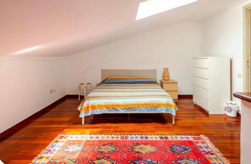 a bedroom with a bed and a rug on a wooden floor at Il Lago e la Luna- Natura, Yoga e Relax in Trevignano Romano