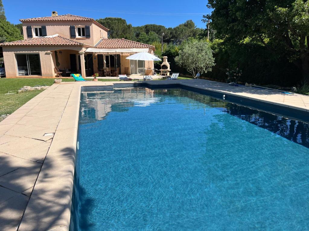 une piscine avec de l'eau bleue devant une maison dans l'établissement Villa Provençale piscine privée, à Saint-Maximin-la-Sainte-Baume
