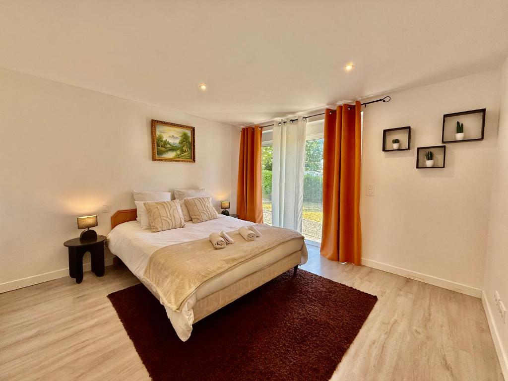 una camera da letto con un grande letto con tende arancioni di Maison spacieuse avec terrasse - DABNB a Saint-Brice-sur-Vienne