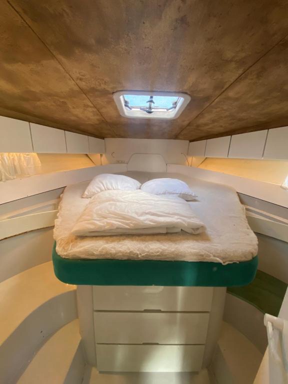 - un lit au milieu d'une petite pièce dans l'établissement BOAT PARADISE LA ROCHELLE - Cranchi Méditerranée 40, à La Rochelle