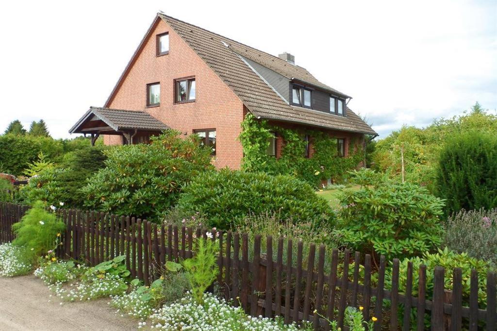 a house with a fence in front of a garden at Ferienwohnung Garmatter Hermannsburg in Hermannsburg
