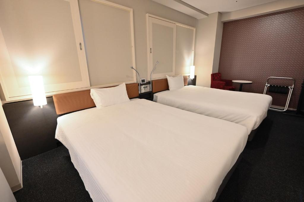 Rúm í herbergi á Sanco Inn Yokkaichi Ekimae