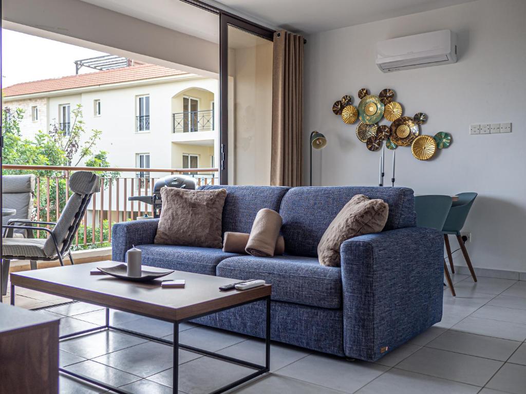 a living room with a blue couch and a table at Cozy sea view Apartment in Mazotos