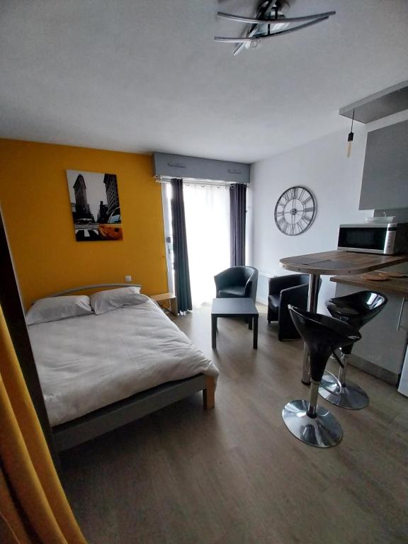 une chambre avec un lit, un bureau et une table dans l'établissement Studio Gabin, à Niort