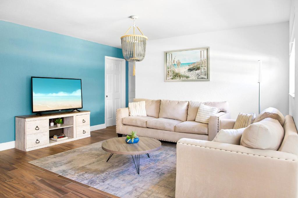 a living room with a couch and a tv at The Coastal Dream! Only 3miles to the beach, Fast WiFi, Garage in Naples