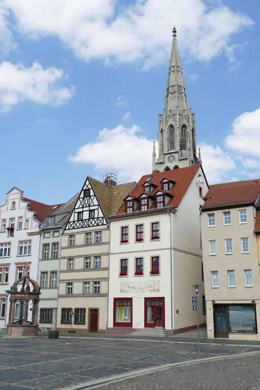 ein großes weißes Gebäude mit einem Kirchturm auf einer Straße in der Unterkunft KERA STAY - Apartments Merseburg in Merseburg