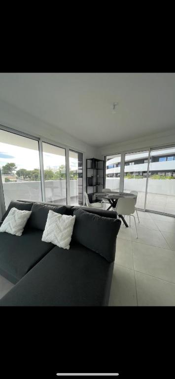 un salon avec un canapé et une table dans l'établissement Appartement 6 personnes Cap d'Agde, au Cap d'Agde