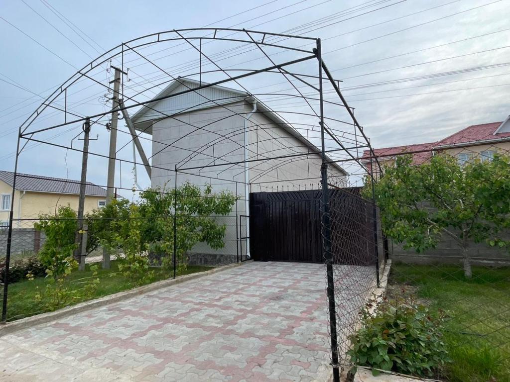 un edificio con una puerta delante de una valla en Edelweiss 1, en Cholpon-Ata