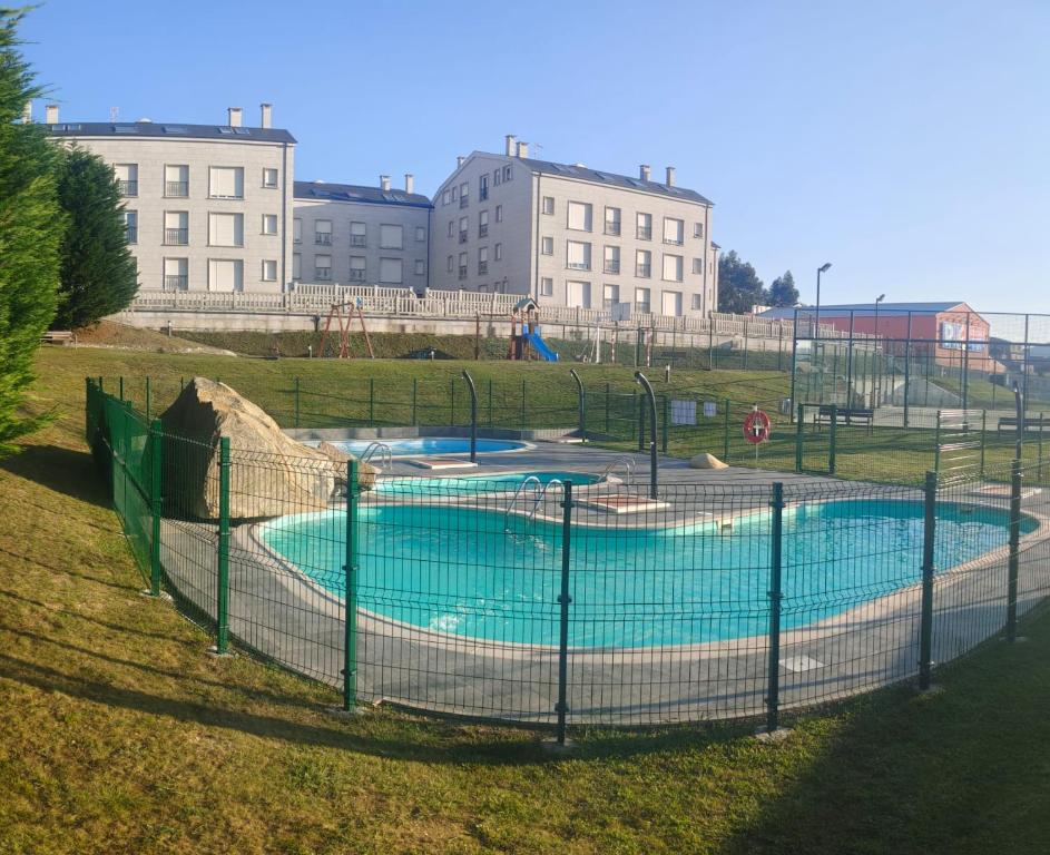 a swimming pool in a field with buildings in the background at Nuestro sueño jurásico in Barreiros
