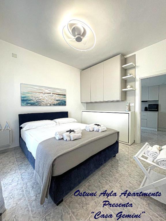 a bedroom with a bed with a ceiling fan at Ostuni Ayla Apartments in Villanova di Ostuni