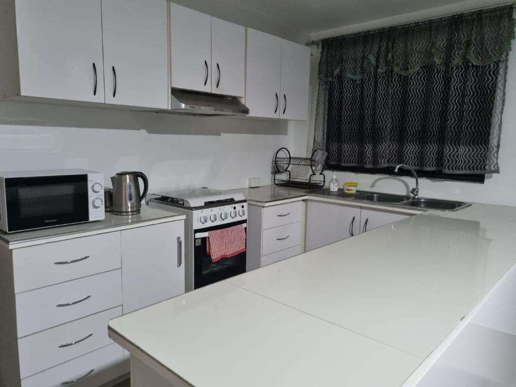a kitchen with white cabinets and a white counter top at Bula Breeze in Nadi