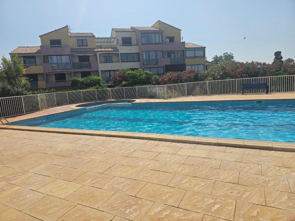 une grande piscine devant un immeuble dans l'établissement Barcarelles au Barcarès Plage Piscine 5 personnes, au Barcarès
