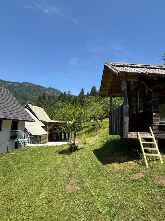 a log cabin in a yard next to a house at Apartma Klemenc in Bohinj