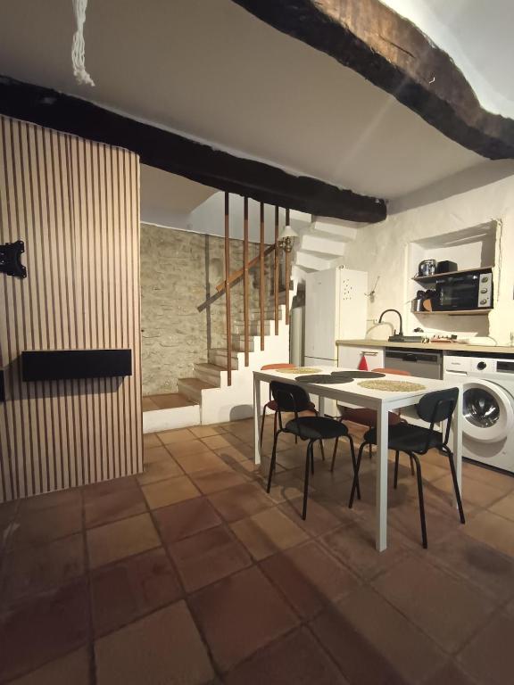 a kitchen with a table and chairs in a room at Villette à Mollans chez Aude & Yo in Mollans-sur-Ouvèze