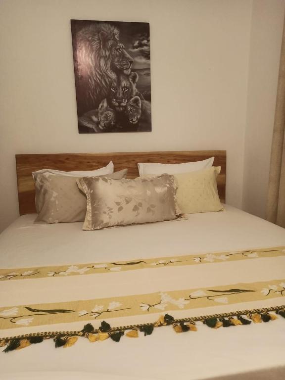 a bed with a wooden headboard and some pillows at SK Homes in Kilifi