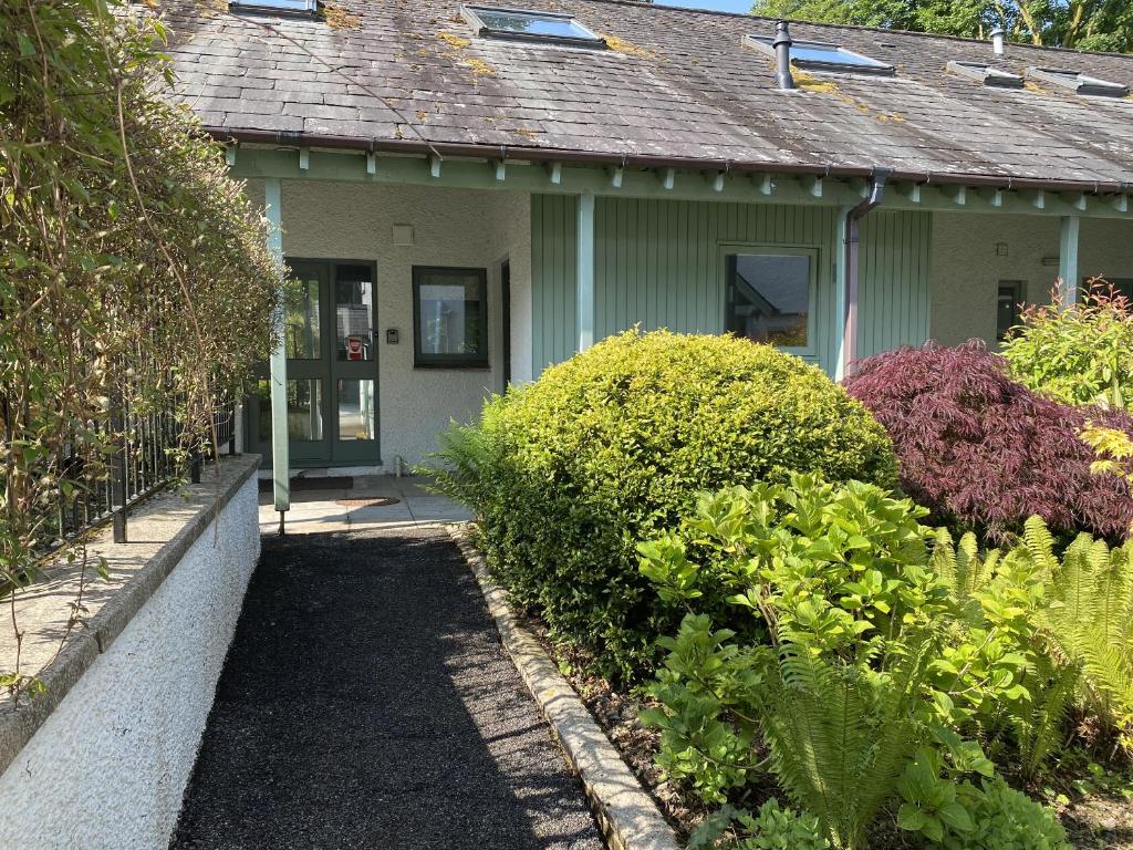 een huis met een loopbrug naar de voordeur bij Beech - Woodland Cottages in Bowness-on-Windermere