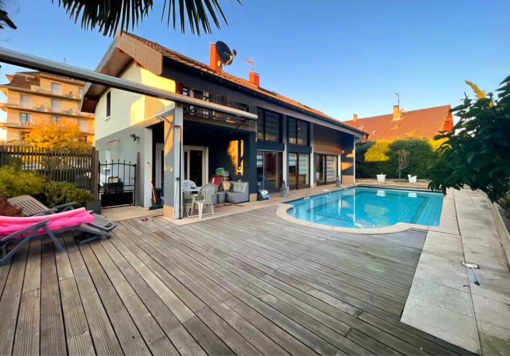 Una casa con terraza de madera y piscina. en Maison, en Maxilly-sur-Léman