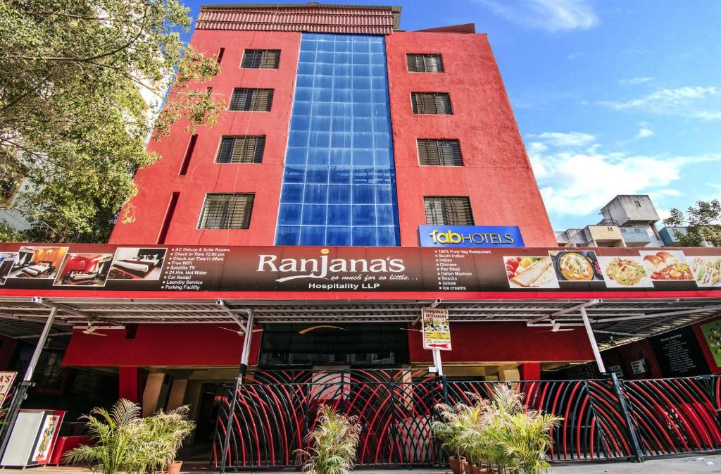a tall red building with a sign on it at FabHotel Ranjanas - Nr humkar Chowk in Pune