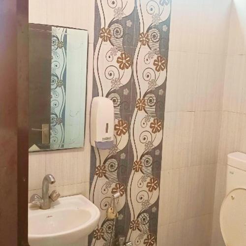 baño con lavabo y teléfono en la pared en Hotel Gem, en Jaipur