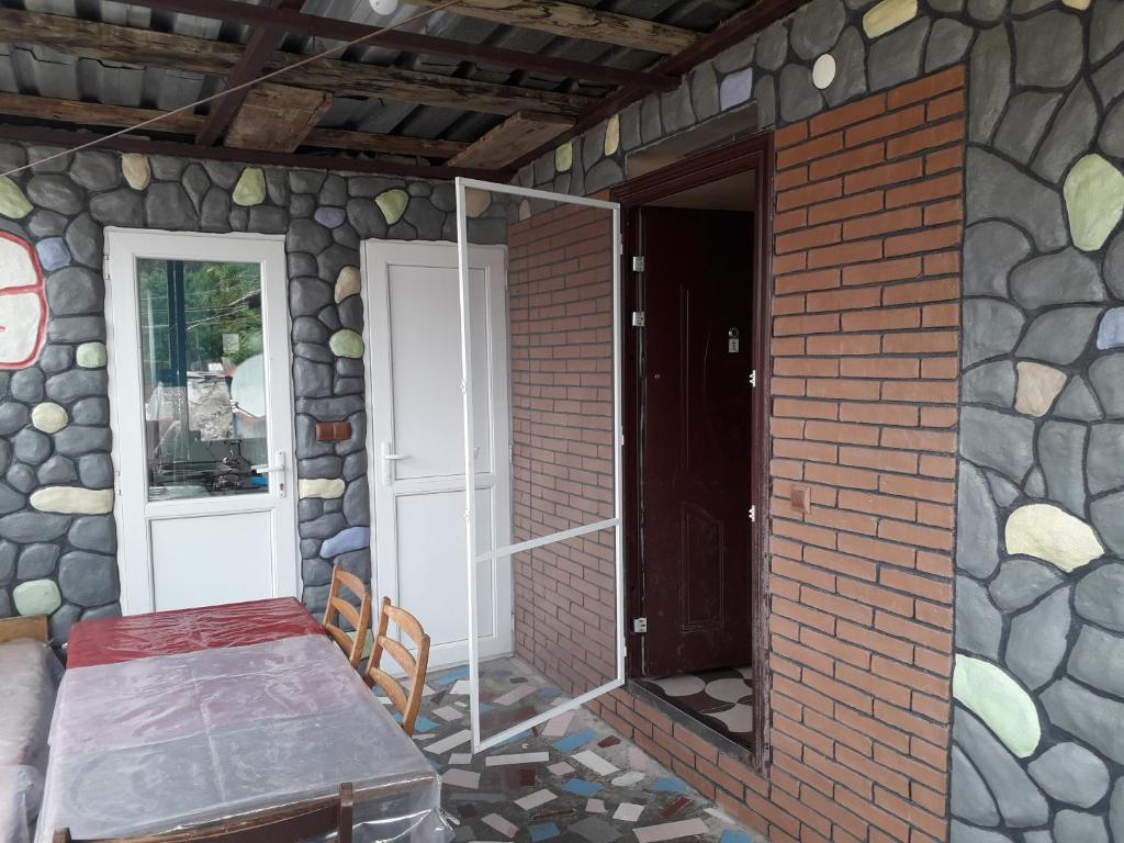 a room with a stone wall and a table and a door at Guesthouse Gurami in Borjomi