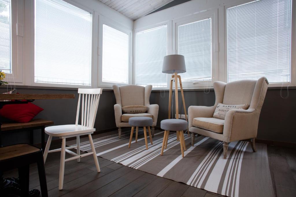 a living room with three chairs and windows at Campus Circuito 71 - Casa per Ferie in Pescara