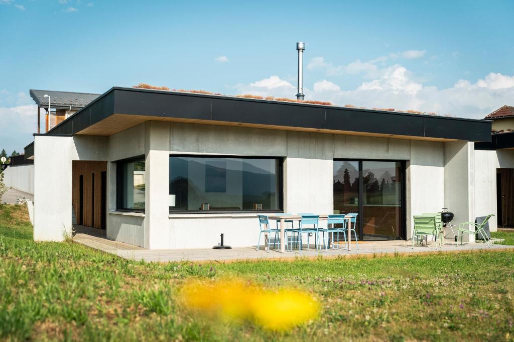 a house with a table and chairs in front of it at Les Terrasses du Noirmont 1 in Les Rousses
