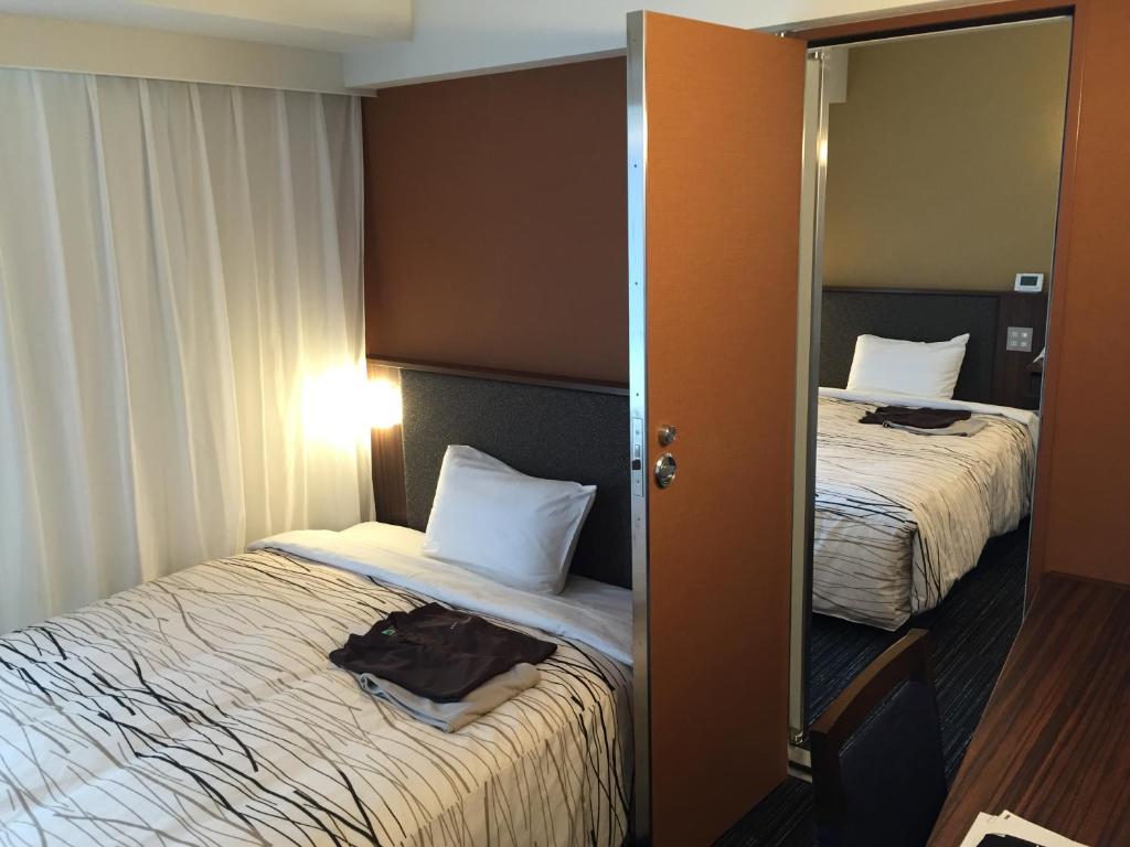 Postel nebo postele na pokoji v ubytování Fukui Manten Hotel Ekimae