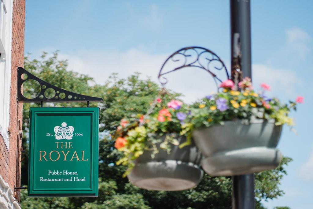 a sign for the royal hotel with flowers in buckets at The Royal Sutton in Sutton Coldfield