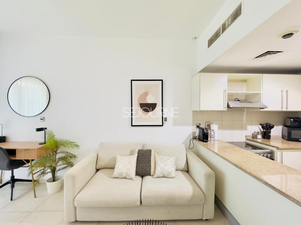 a living room with a couch and a kitchen at DA86 - Well Design Studio in Dubai Arch tower in Dubai