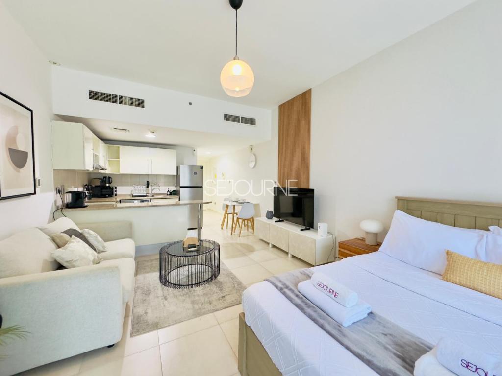 a bedroom with a bed and a living room at DA86 - Well Design Studio in Dubai Arch tower in Dubai