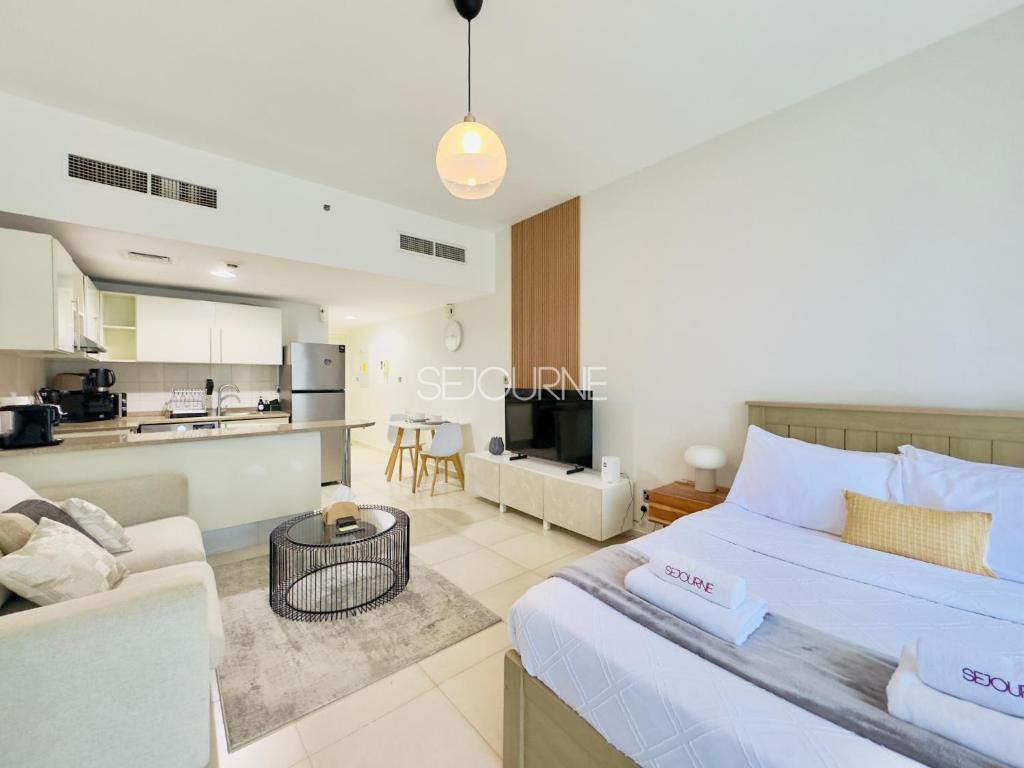 a bedroom with a bed and a living room at DA86 - Well Design Studio in Dubai Arch tower in Dubai