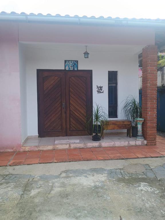 a wooden door and a bench in front of a house at Ambiente Familiar in Ubatuba