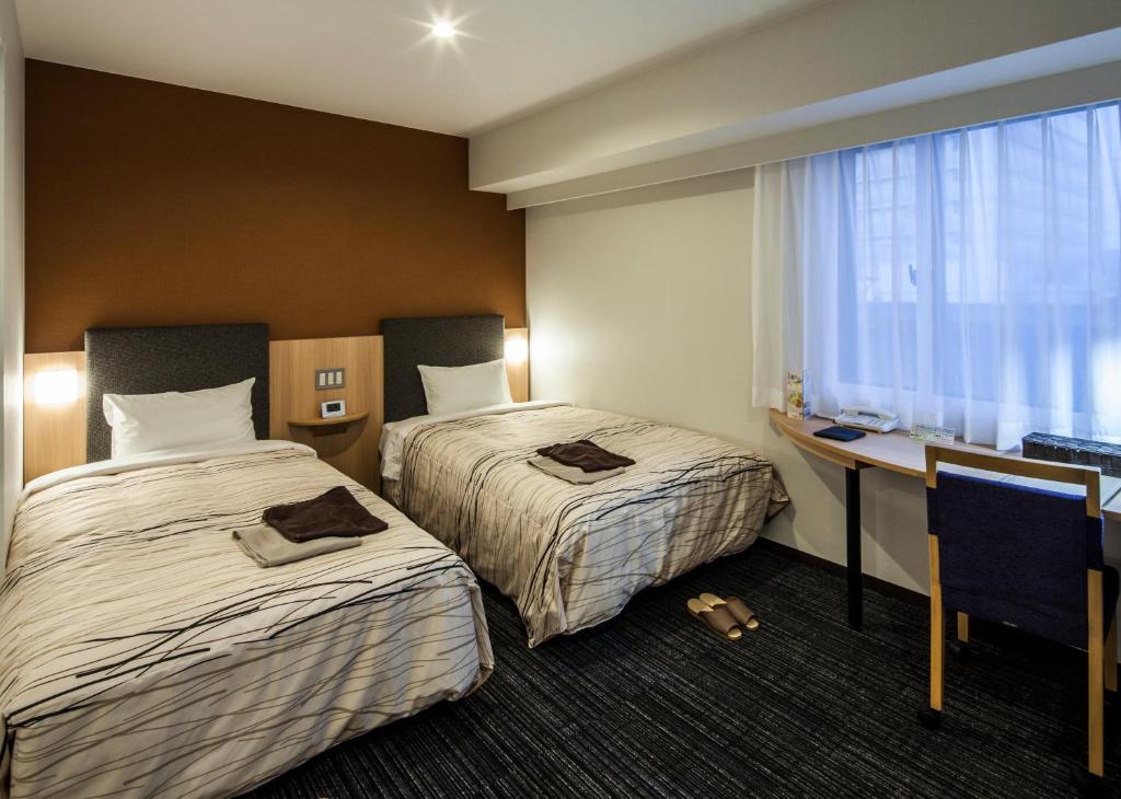 Postel nebo postele na pokoji v ubytování Fukui Manten Hotel Ekimae