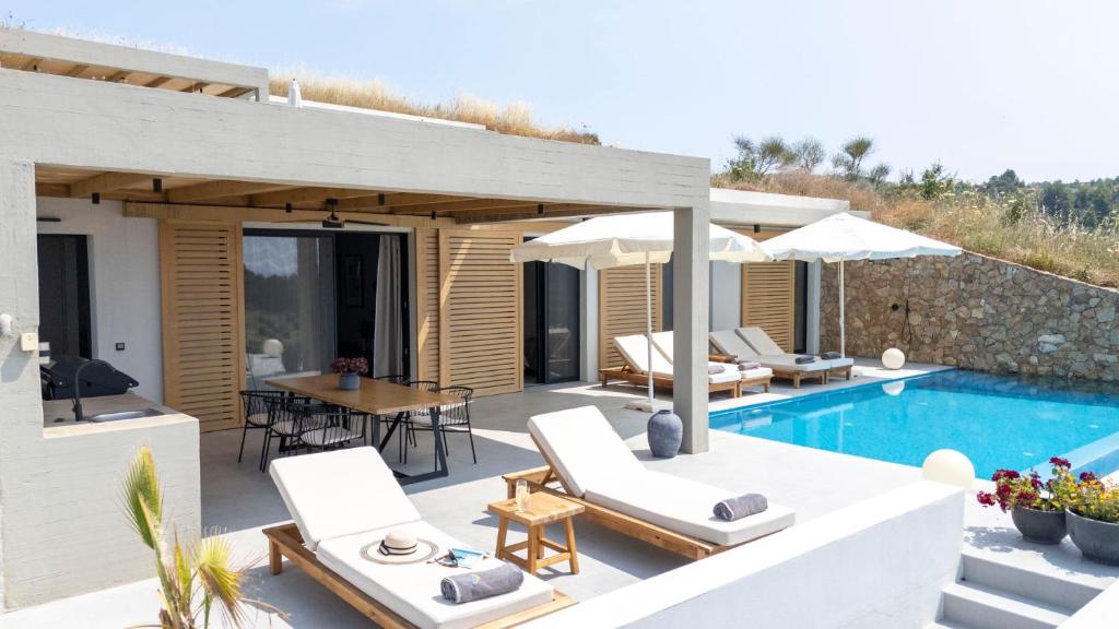 eine Villa mit Swimmingpool und ein Haus in der Unterkunft Villa Lume Nea Skioni by Halkidiki Villas in Nea Skioni