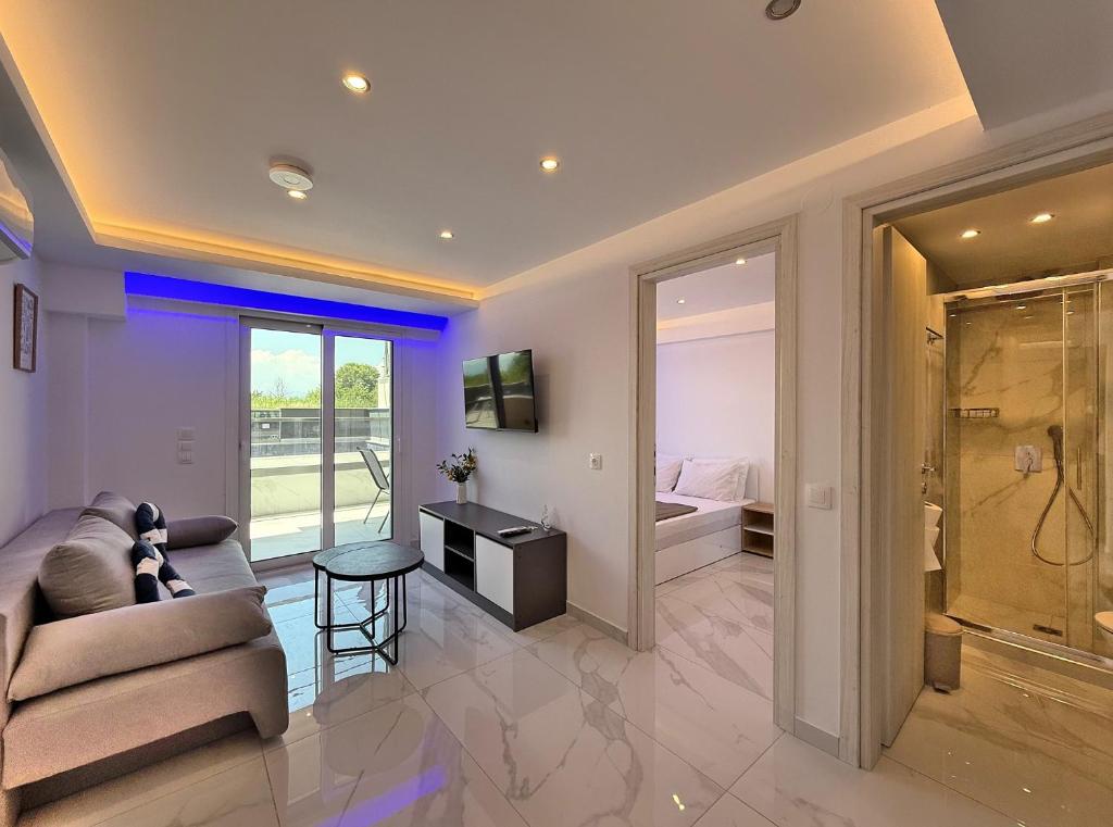 a living room with a couch and a room with a bedroom at IFESTOS SUITES by SDR in Paralia Katerinis