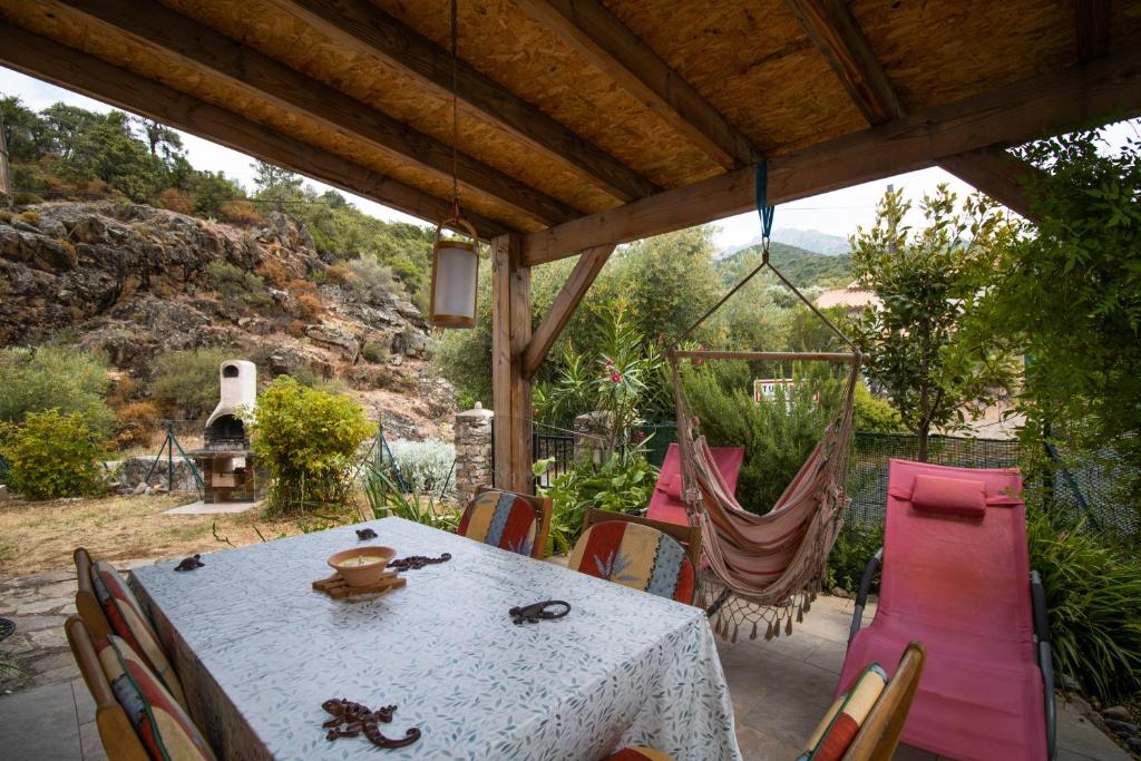 - une table et des chaises sur la terrasse dans l'établissement Au Pont De Tuarelli, Ludique, Fango, à Manso