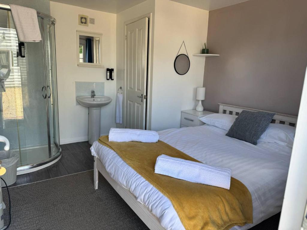 a bedroom with a bed with two towels on it at Cabin 6 in Bradwell on Sea