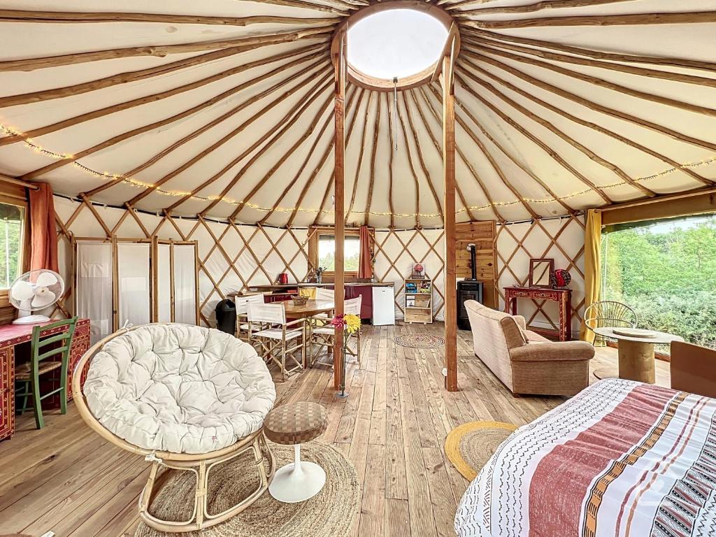 a bedroom in a yurt with a bed and chairs at Yourte nature & calme proche Futuroscope in Archigny