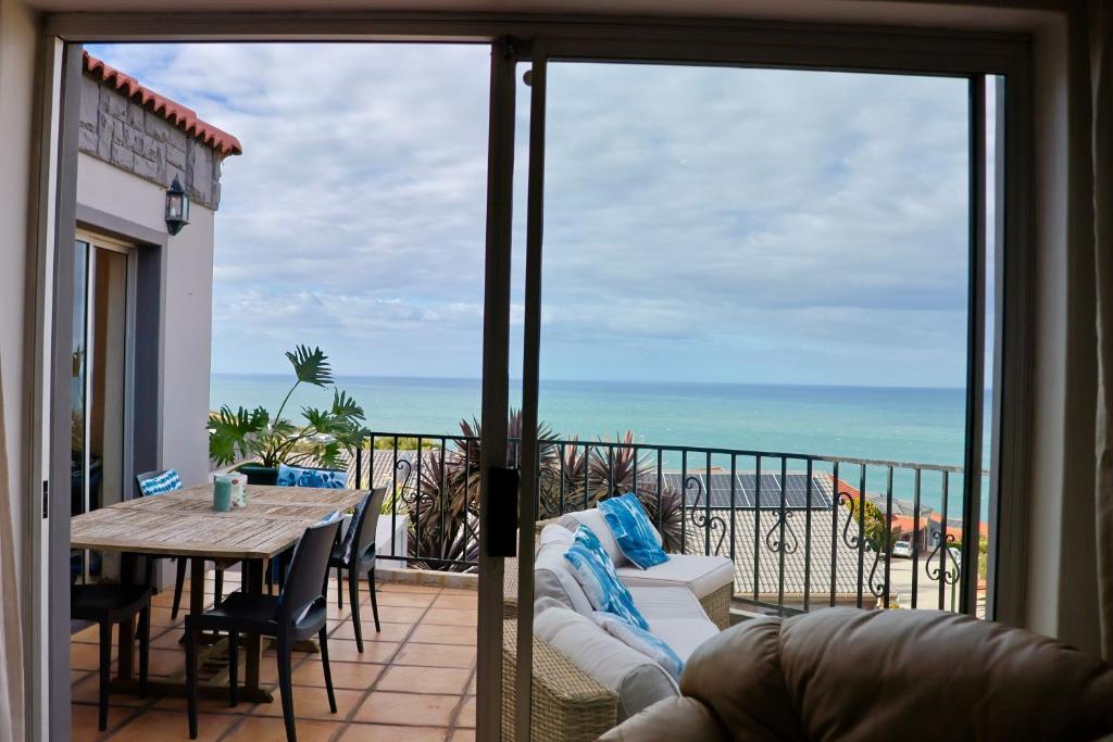 un balcone con tavolo e vista sull'oceano di Apartment Sapphire a Herolds Bay