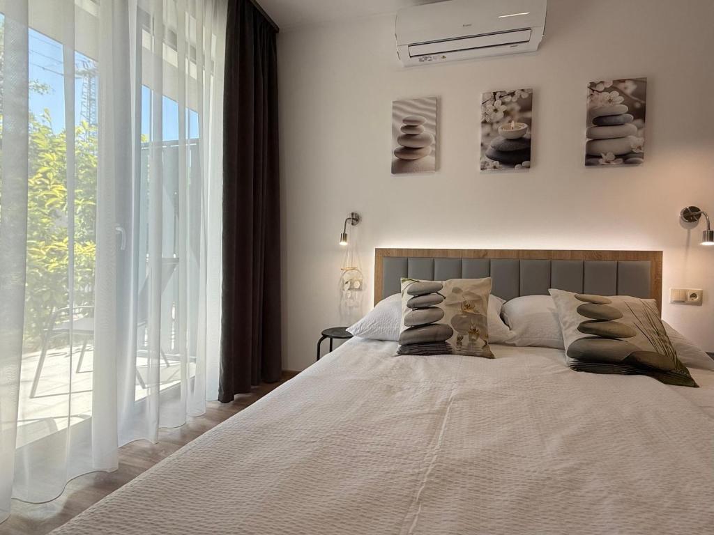 a bedroom with a large bed and a large window at Zen apartmanház Gyula in Gyula
