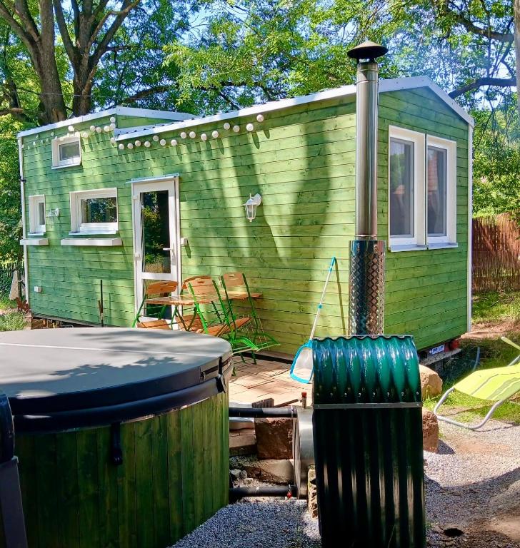 a green tiny house with a trash can in front of it at NEW! Tiny house U Jelena, hot tub in Trutnov