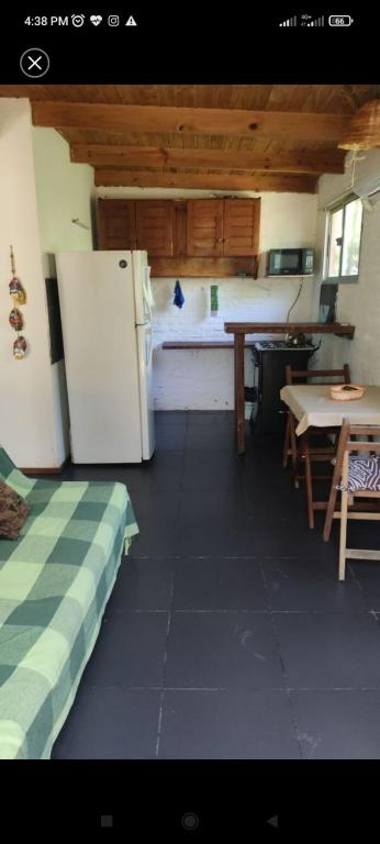 a kitchen with a refrigerator and a table in it at Surf homes in La Floresta